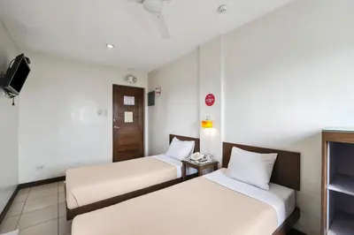 a hotel room with two beds and a tv at Governor Forbes Inn - Manila City Center in Manila