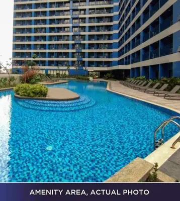 an empty swimming pool in front of a large building at 1 Bedroom with Balcony at Air Residences, Makati in Manila