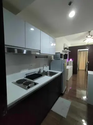 a white kitchen with a sink and a refrigerator at 1 Bedroom with Balcony at Air Residences, Makati in Manila