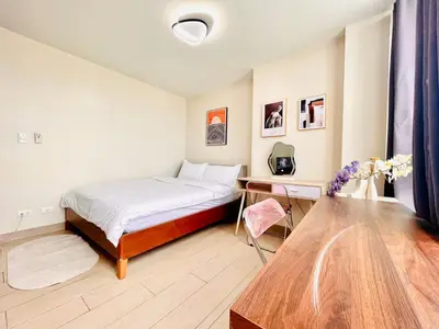 a bedroom with a bed and a wooden table at 1 Queen Bed & 2 double beds at One Uptown Residences with XBOX and Netflix in Manila