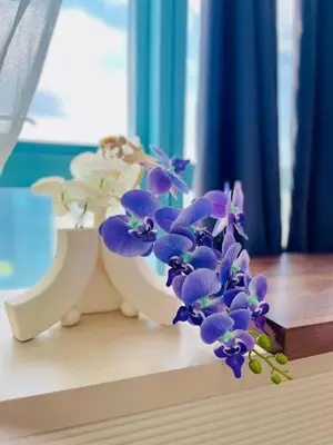 a white vase filled with purple flowers on a table at 1 Queen Bed & 2 double beds at One Uptown Residences with XBOX and Netflix in Manila