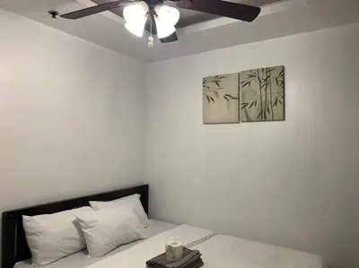 a bedroom with a bed with a ceiling fan at Birch Tower a3 front of Robinson Mla FREEpool in Manila