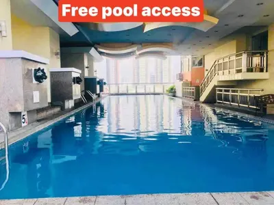 a pool in a hotel room with blue water at Birch Tower a3 front of Robinson Mla FREEpool in Manila