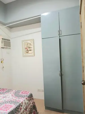 a bedroom with a large white refrigerator next to a bed at Centro Tower - 2 Bedroom Fully Furnished in Manila