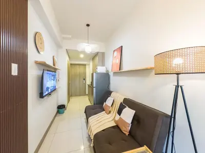 a living room with a couch and a tv at GemstoneBR in SMDC Coast Residences in Manila