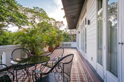 a balcony with chairs and tables on a porch at The Henry Hotel Manila in Manila
