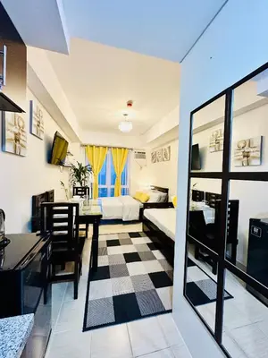a living room with a table and a dining room at The 23rd Haven by Kasara Urban Resort Residences in Manila