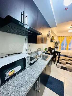 a kitchen with a sink and a microwave at The 23rd Haven by Kasara Urban Resort Residences in Manila