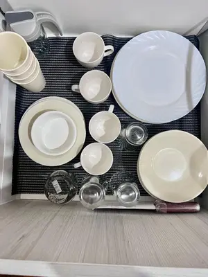 a table with white plates and bowls and utensils at Acqua Private Residences - Iguazu Tower 36th flr Mandaluyong - Makati in Manila