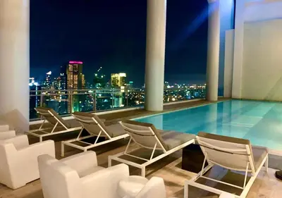 a rooftop pool with chairs and a view of the city at Acqua Private Residences - Iguazu Tower 36th flr Mandaluyong - Makati in Manila