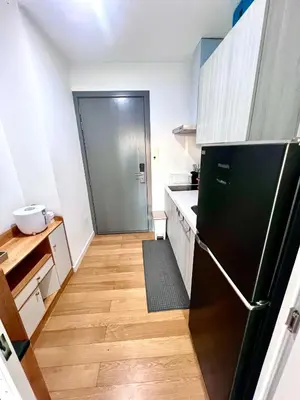 a kitchen with a black refrigerator and a wooden floor at Acqua Private Residences - Iguazu Tower 36th flr Mandaluyong - Makati in Manila