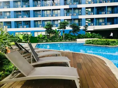 a swimming pool with lounge chairs and a building at Mon ciel suite Spacious 1BR Air Residence SMDC in Manila