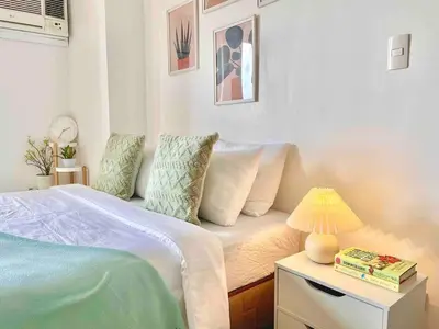 a bedroom with a bed and a table with a lamp at Luxury Bgc Condo Near Venice Mall #vlra22e in Manila