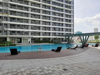 a large building with a swimming pool in front of a building at SMDC Fame Marcelle's Place near Mega Mall in Manila
