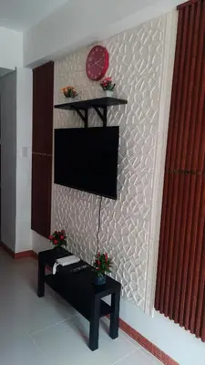 a living room with a tv on a wall at SMDC Fame Marcelle's Place near Mega Mall in Manila