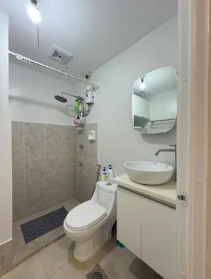 a bathroom with a toilet and a sink and a mirror at Modern Simplicity: Cozy @Nuvali in Pitland