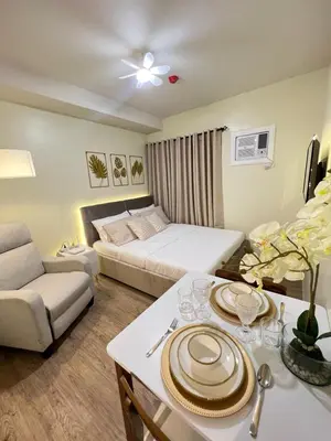 a hotel room with a bed and a table with plates on it at Condo near Nuvali Laguna Technopark St Benedict Church in Bayabasan
