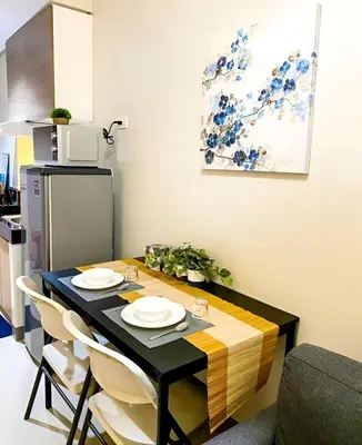 a dining room table with white plates on it at Casa Aria at SMDC Charm Residences - No Parking in Manila