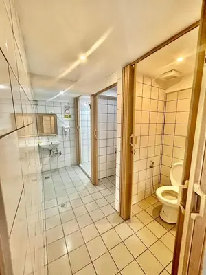 a bathroom with a toilet and a sink at Courtyard Hotel in Manila