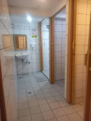 a bathroom with a shower and a sink at Courtyard Hotel in Manila
