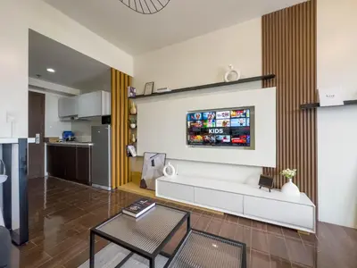 a living room with a white couch and a kitchen at GemstoneBR in SMDC Air Residences in Manila