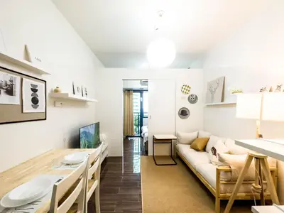 a living room and dining room with a couch and a table at GemstoneBR in SMDC Air Residences in Manila