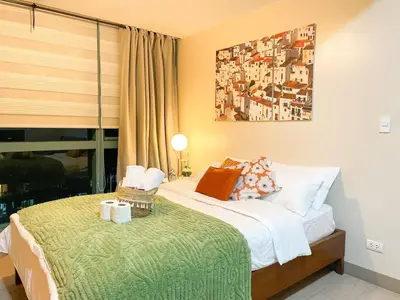a bedroom with a bed with a green blanket at Chillhive Condo In Bgc Near Uptown Mall #ournw17a in Manila