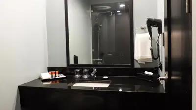 a bathroom with a black sink and a mirror at Amelie Hotel Manila in Manila