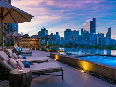 a rooftop patio with a swimming pool and a city skyline at Discovery Primea in Manila