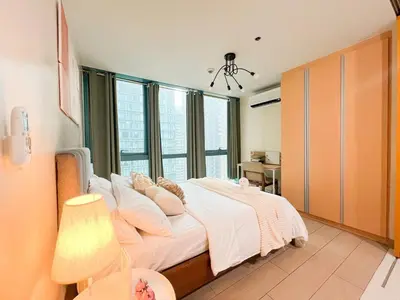 a bedroom with a bed with white sheets and pillows at Bgc Condo Near Uptown Mall, Grand Hyatt #ournw25b in Manila