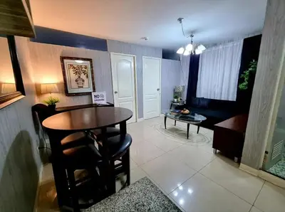 a living room with a table and a dining room at Romantic 2BR Condo unit with free WiFi in Anabu Primero