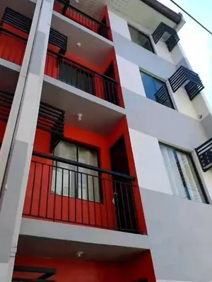 an apartment building with red doors and balcony at Romantic 2BR Condo unit with free WiFi in Anabu Primero
