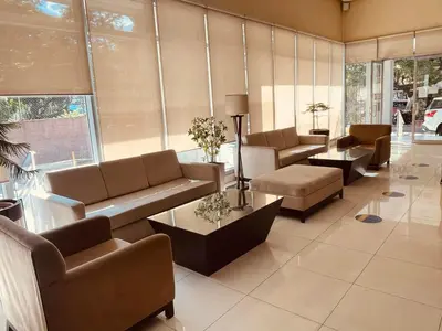 a living room with couches and tables and windows at Condo in Ermita near UP-PGH, St Lukes & US Embassy in Manila