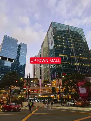 a tall building with a sign on it in a city at Cozy Stay In Bgc Near Uptown Mall #oursw11d1 in Manila
