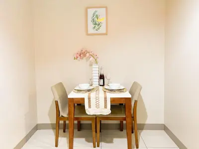 a dining room table with chairs and a vase of flowers at Cozy Stay In Bgc Near Uptown Mall #oursw11d1 in Manila