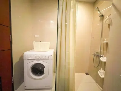 a washing machine in a bathroom with a shower at Top BGC Condo Across Grand Hyatt Hotel #oursw12k in Manila