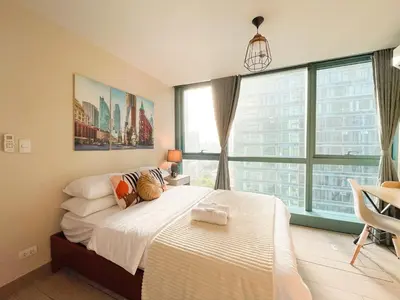 a bedroom with a bed and a large window at Upscale Bgc Experience 1br Condo #oursw17c2 in Manila