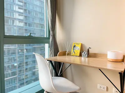 a desk with a chair next to a window at Upscale Bgc Experience 1br Condo #oursw17c2 in Manila