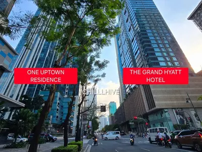 two red signs on a city street with buildings at Luxury Bgc Condo At Uptown Area #oursw21e in Manila