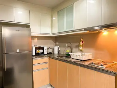 a kitchen with white cabinets and a stainless steel refrigerator at Bgc Staycation Across Uptown Mall #oursw29f in Manila