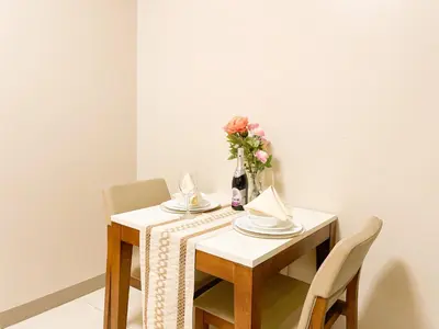 a table with chairs and a vase with flowers on it at Luxury BGC Condo, Steps to Uptown Mall #oursw31i in Manila