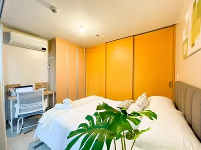 a bedroom with a bed and a desk with a laptop at Bgc 1br Condo Across Uptown Mall, Hyatt #oursw7b2 in Manila