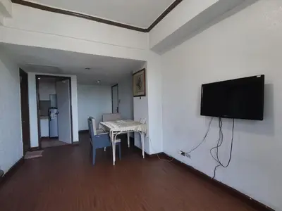 a room with a table and a tv on a wall at Room accommodation in Manila
