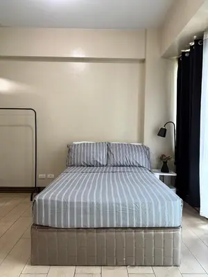 a bedroom with a bed with blue and white stripes at Runway Walk Studio - Near NAIA Terminal3 in Manila