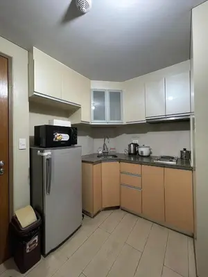 a kitchen with white cabinets and a refrigerator at Runway Walk Studio - Near NAIA Terminal3 in Manila