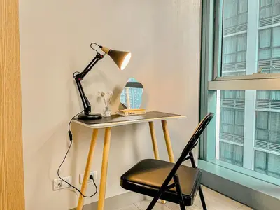 a desk with a lamp and a chair next to a window at Prime Bgc Stay Near Uptown, Grand Hyatt #oursw18j in Manila