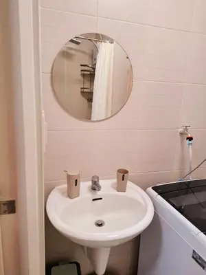 a bathroom with a sink and a mirror at Serene Suite In Jazz Residences in Manila