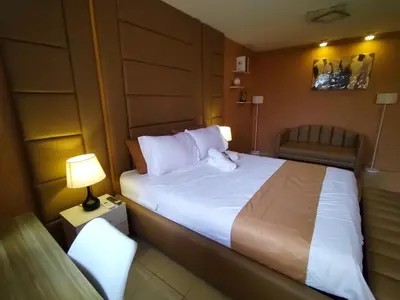 a hotel room with a large bed and a chair at The Barracks Staycation in Santa Rosa