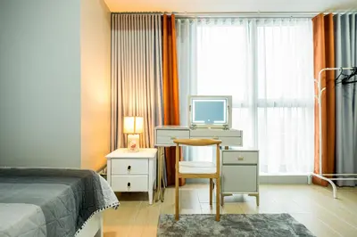 a bedroom with a bed and a tv and a chair at BGC 2BR Uptown Parksuites with balcony and bathtub in Manila