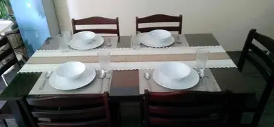 a dining room table with white plates and chairs at Urban Zen in Calamba